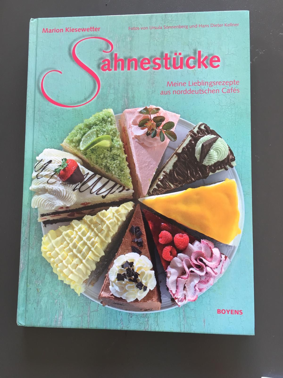 A cookbook titled Sahnestucke showing colorful cake slices arranged in a circle on turquoise background.
