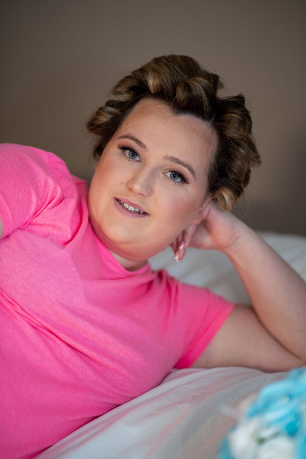 Casual portrait of someone wearing a bright pink shirt while lying down.