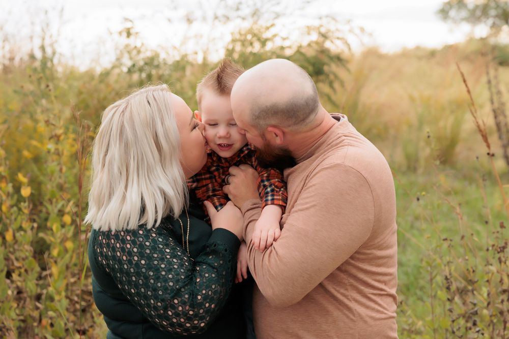 A tender family moment captured in a field of golden autumn grasses.