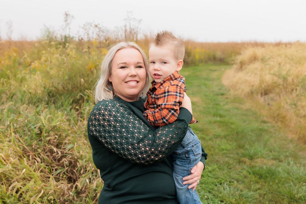 A sweet candid moment captured outdoors against a backdrop of autumn wildflowers.