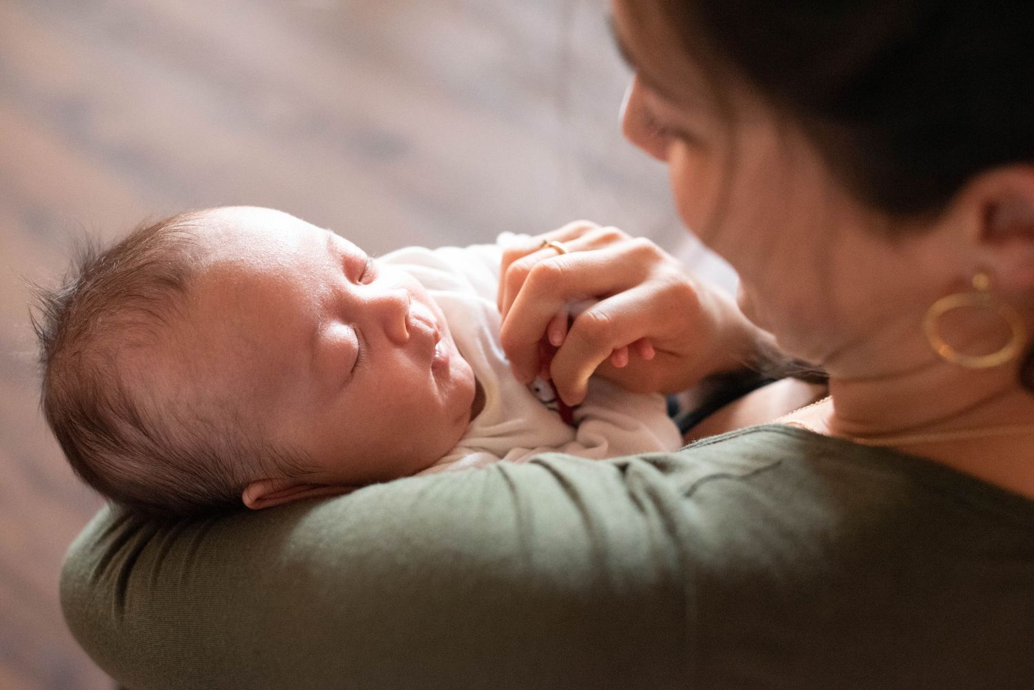 Photo of mom lovingly staring into newborns face.