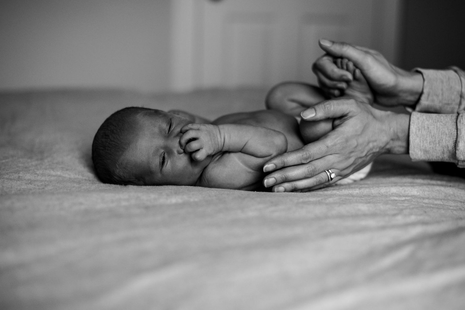 Mom's hands wrapped around a newborn baby.