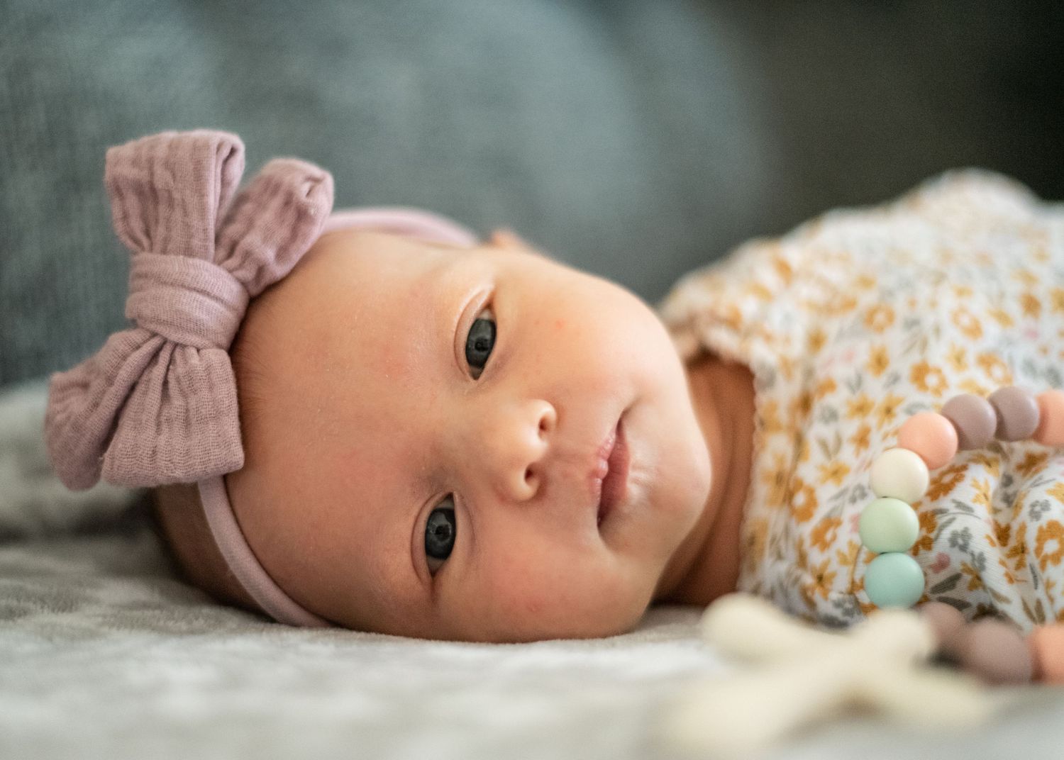newborn photograph of a little girl with a bow.