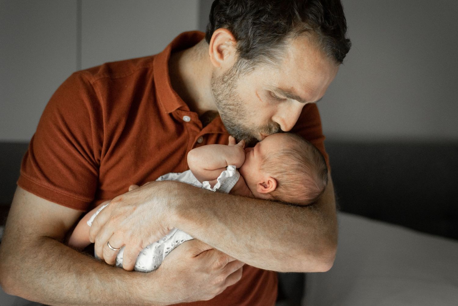 Picture of dad kissing the newborn.