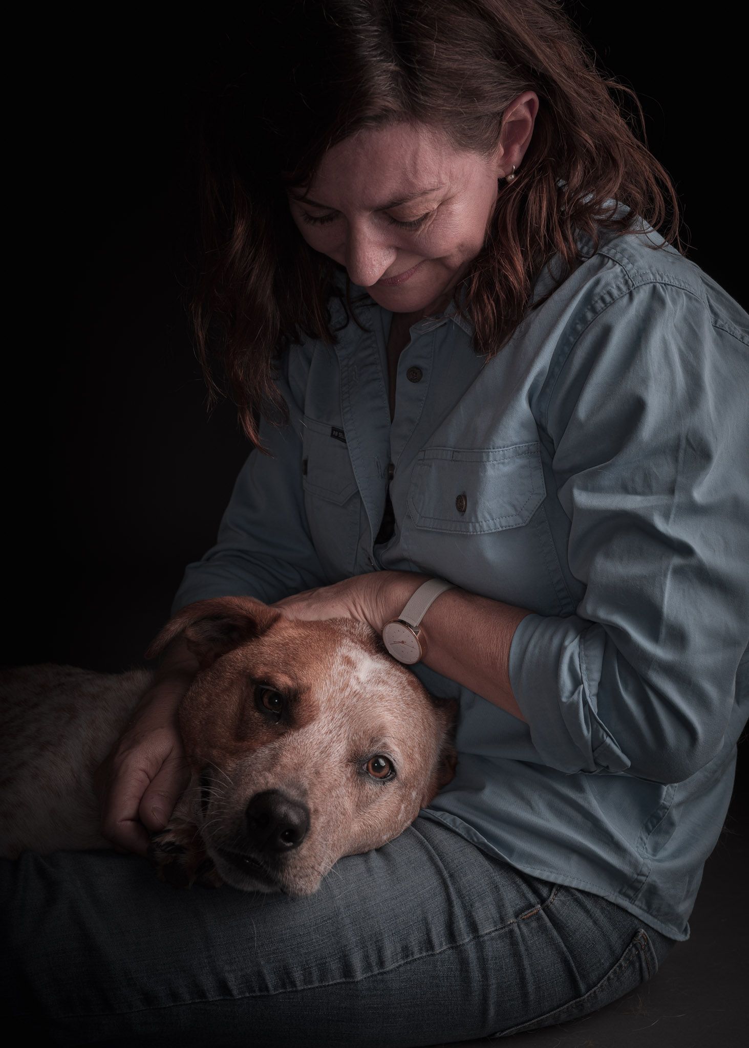 Woman posing with her dog in a studio portrait session