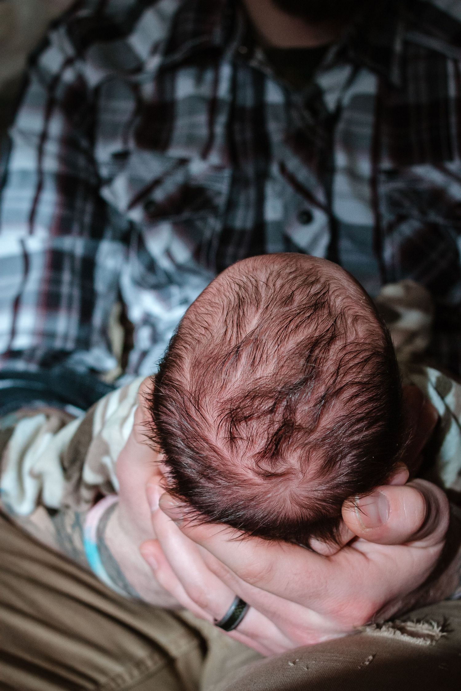 Baby boy in his dad's hands during his fresh 48 session in Sioux City, IA.