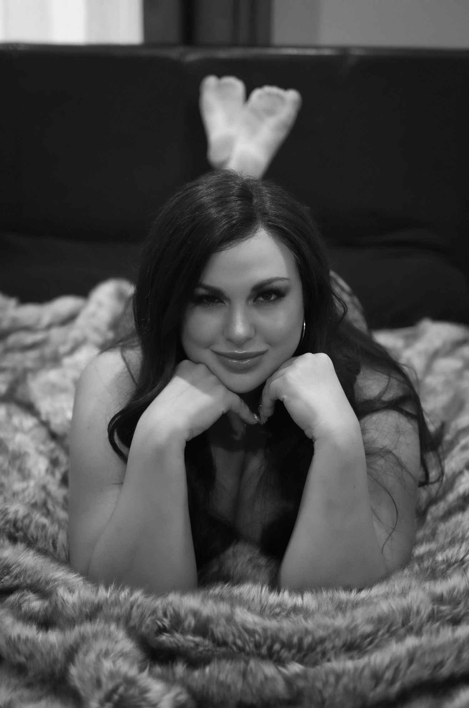 A boudoir photography session featuring intimate poses in a dimly lit bedroom setting.