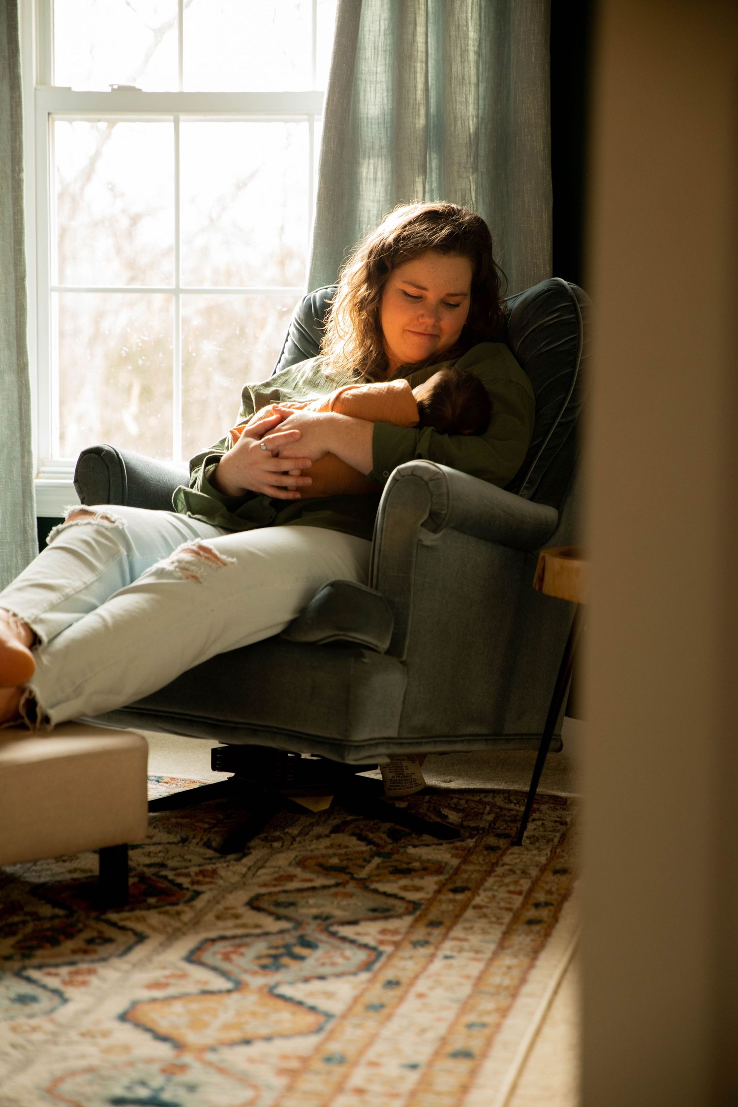 Peaceful scene of relaxation in a recliner by a bright window with a patterned rug.