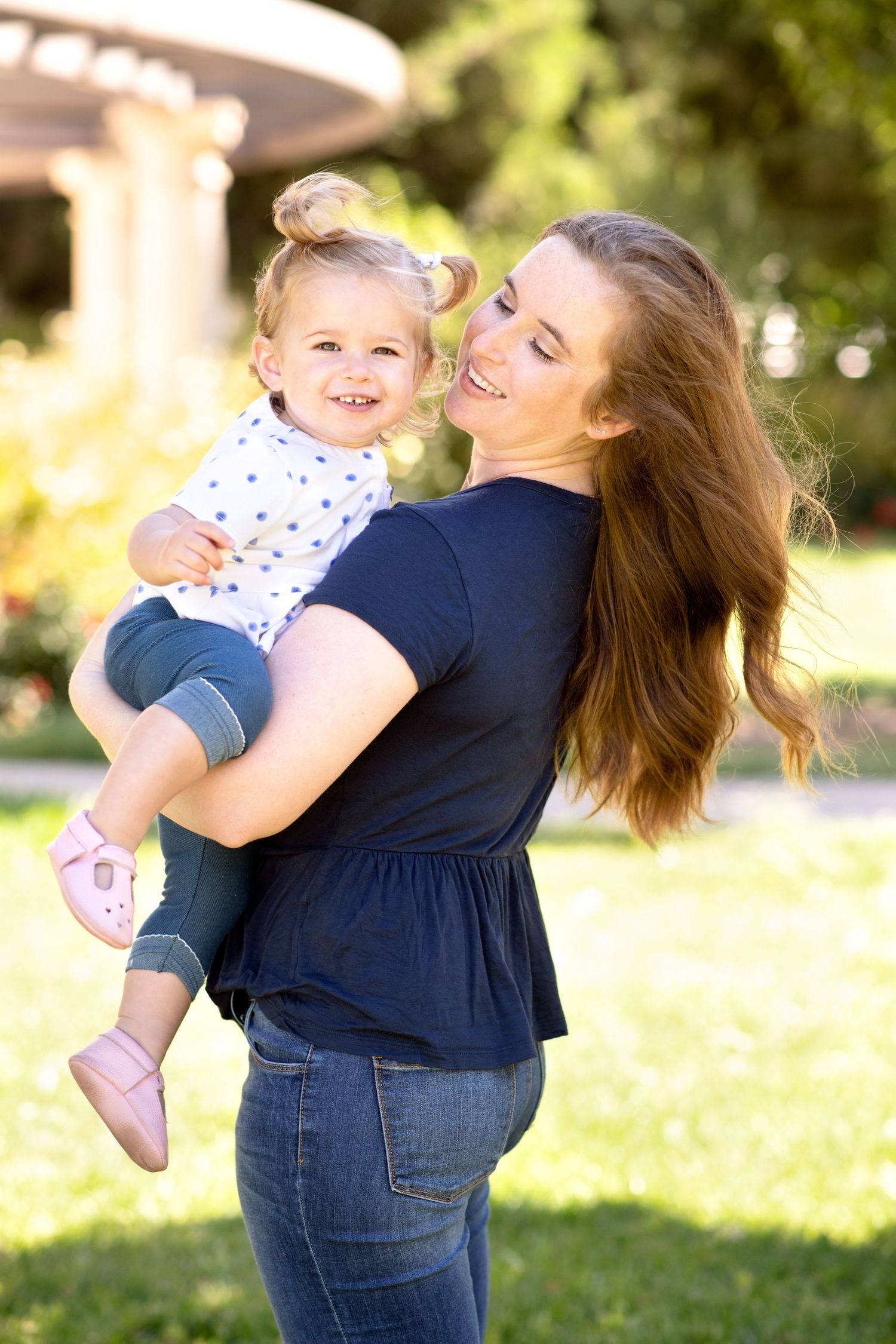 Playful outdoor mother and child portrait series in natural sunlit setting.
