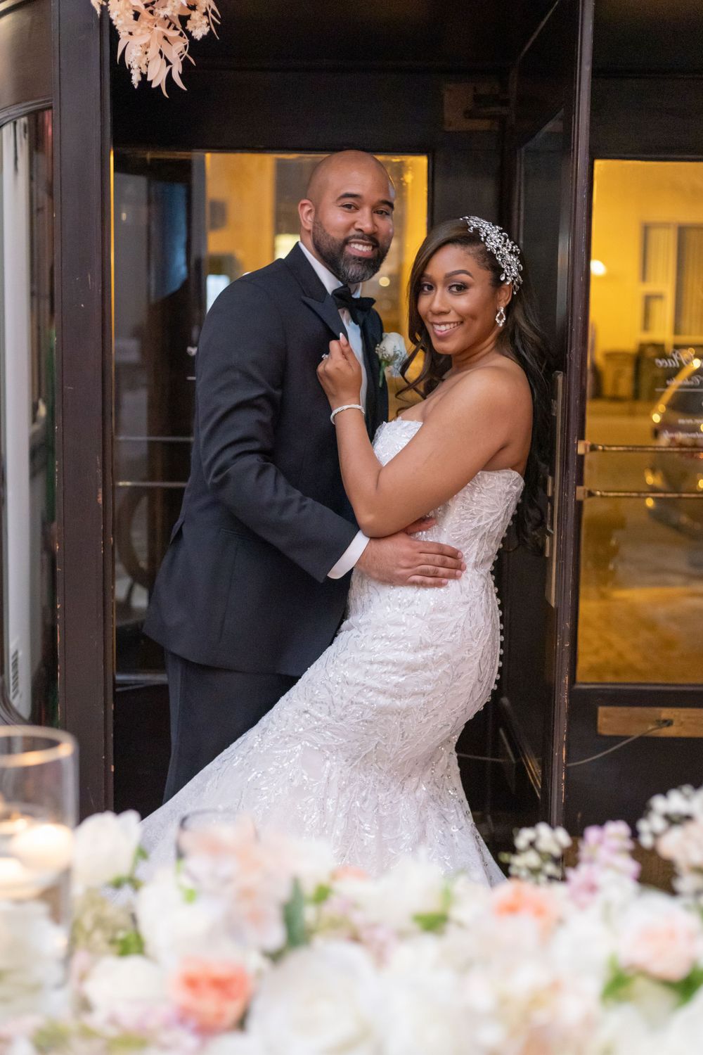 Elegant wedding portrait featuring ornate floral decor and romantic lighting.