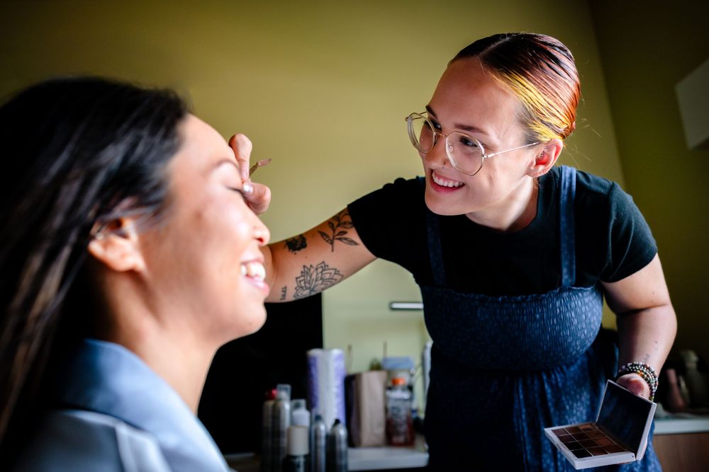Professional makeup artist applying cosmetics in a salon setting.
