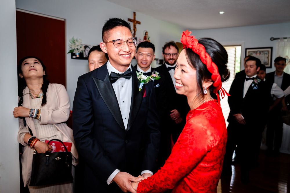 Wedding celebration indoors with guests in formal attire mingling and dancing.