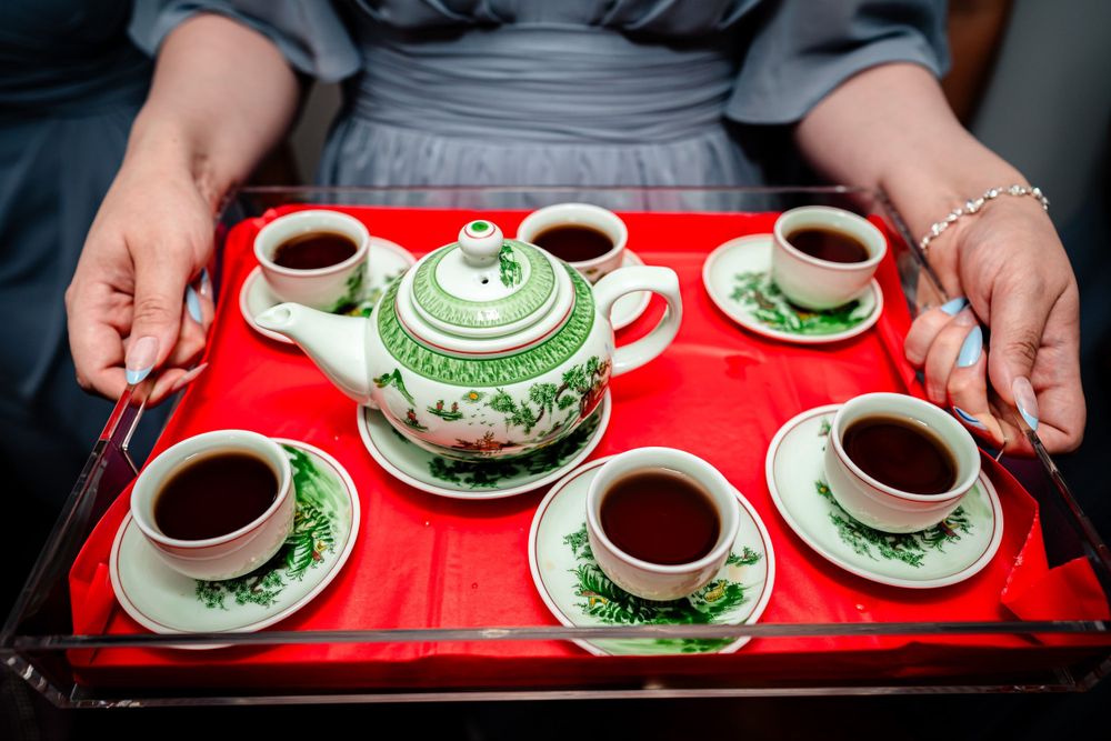 Traditional tea service with green and red accents displayed on serving tray.