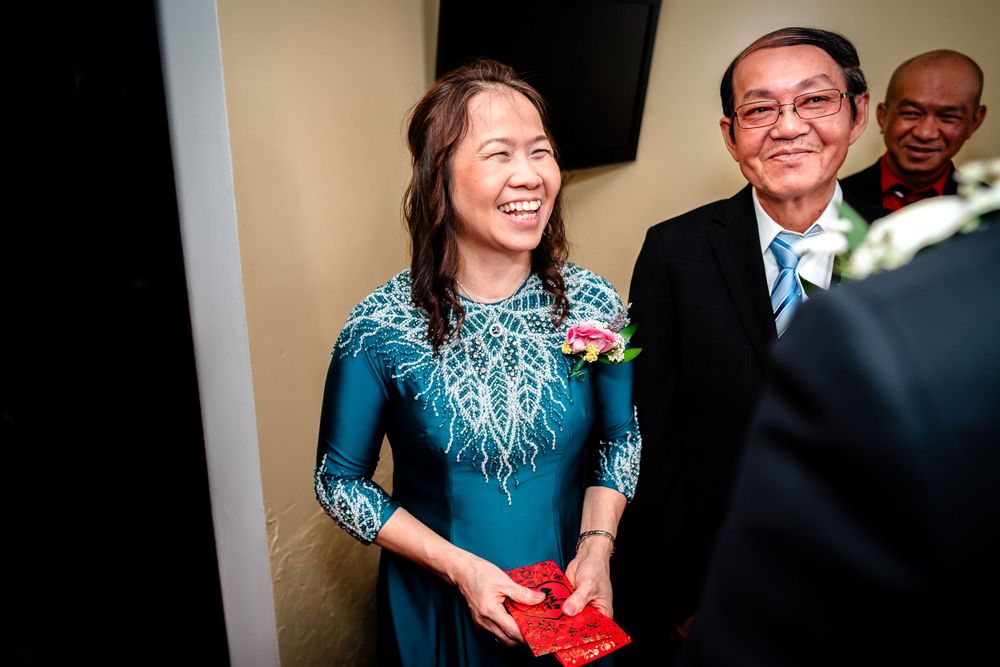 Wedding guests participate in a traditional tea ceremony with delicate cups and smiles.