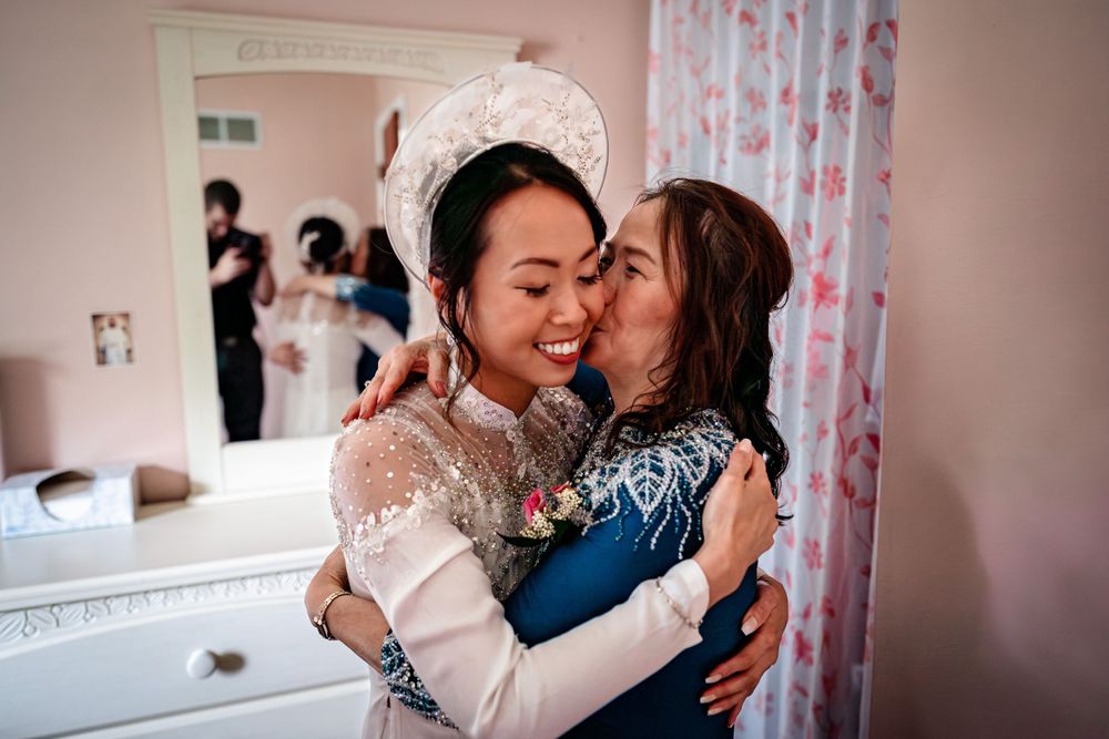 Emotional moments shared between family members during wedding preparations in a pink-tinted room.