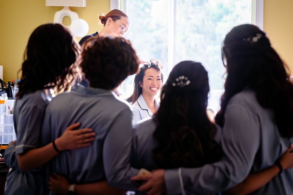 Group gathered for wedding preparation in a bright indoor setting.