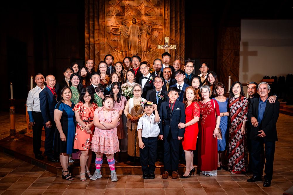 Large group wedding photo with guests gathered inside a church for formal portraits.