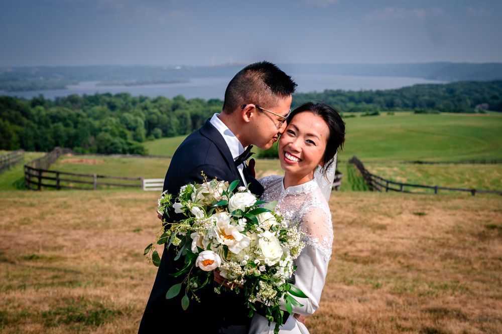 Romantic wedding portraits captured against rolling hills and scenic countryside views.