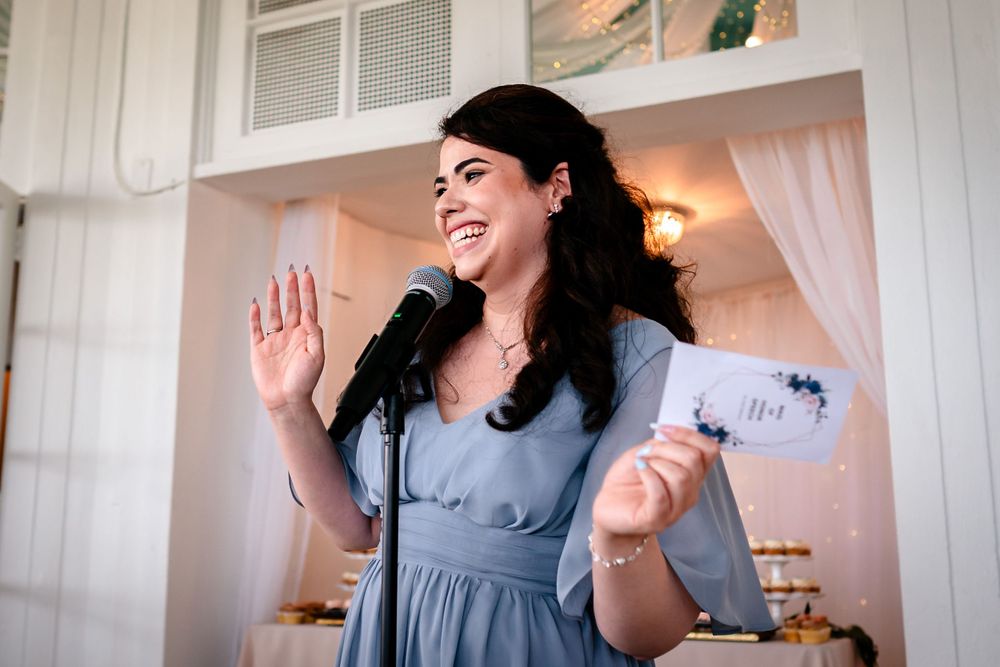 Bridesmaids in blue dresses sharing joyful moments in a bright white room.