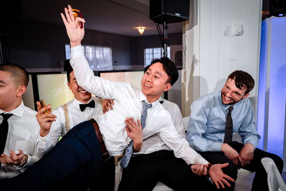 Energetic dancing and celebration captured at an indoor wedding reception.