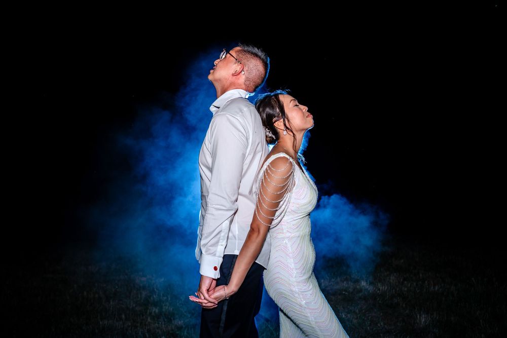 Dramatic nighttime wedding photos with blue smoke effects and lighting.