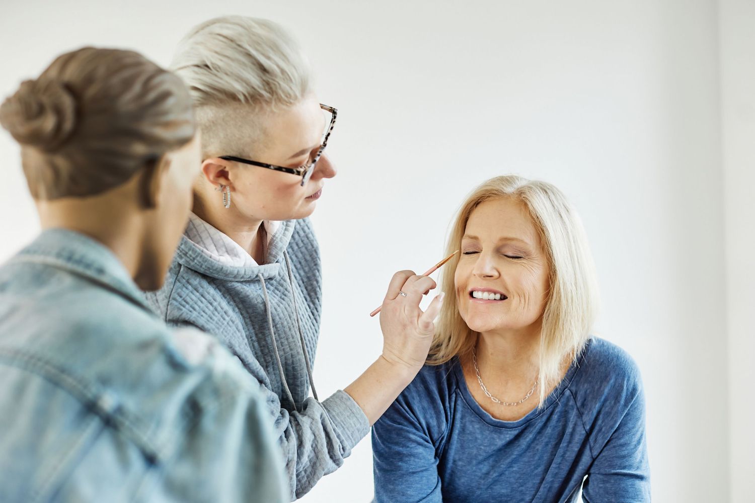 A makeup application session in progress against a white background.