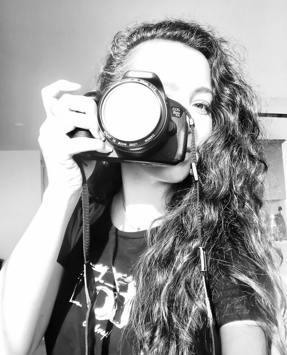 Black and white portrait of a photographer holding a professional camera.