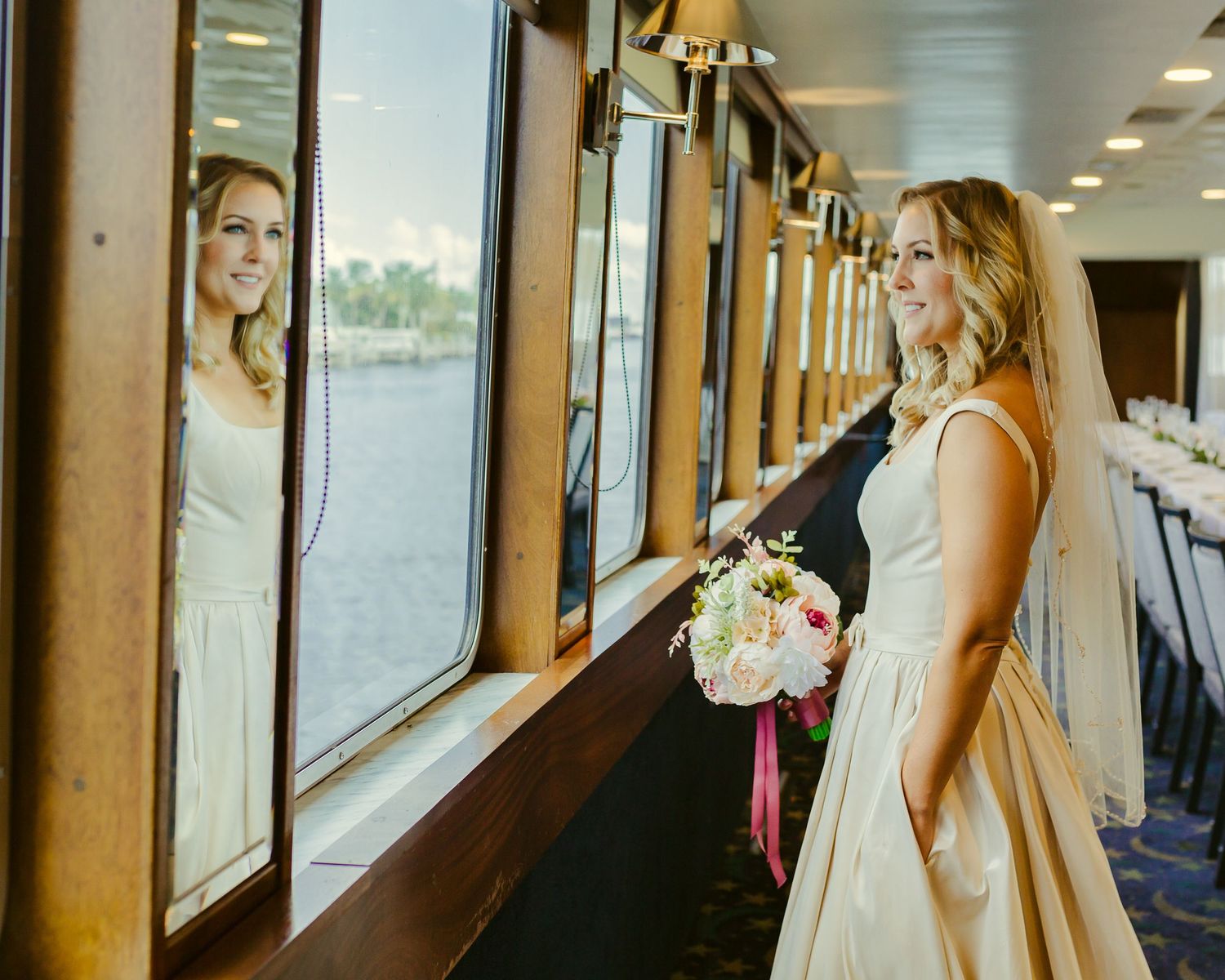 bride looking out of the ship with her bouquet at hand and hand in pocket