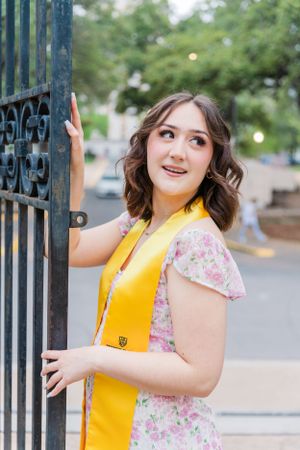 female college graduate portrait with gate