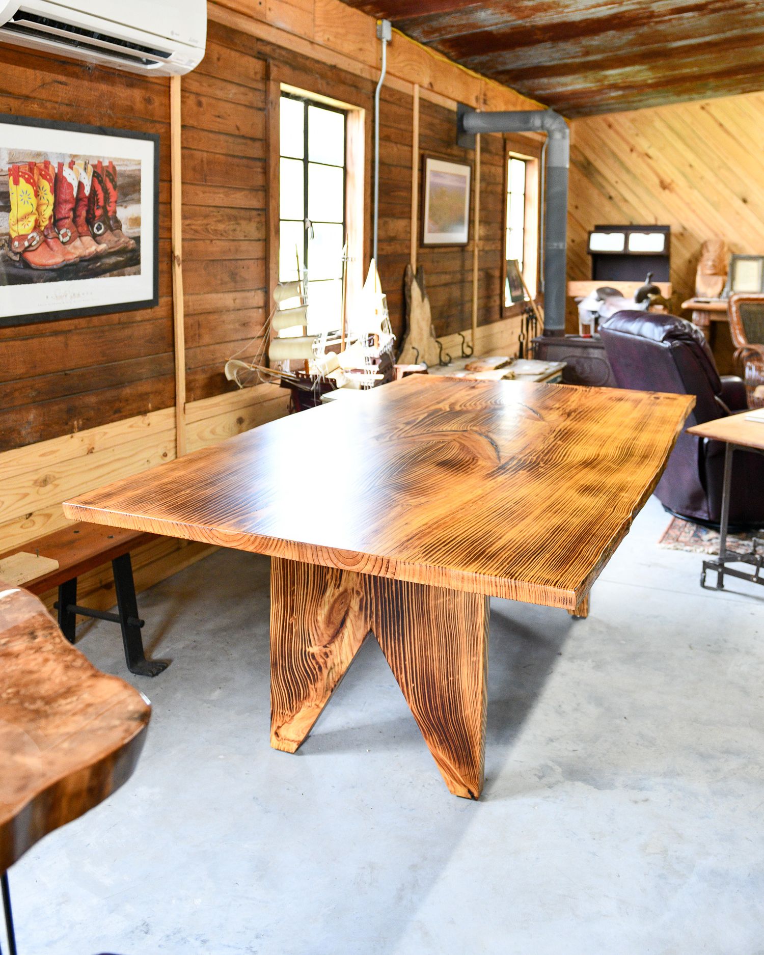 Large live edge wooden dining table with distinctive butterfly base in a rustic room.