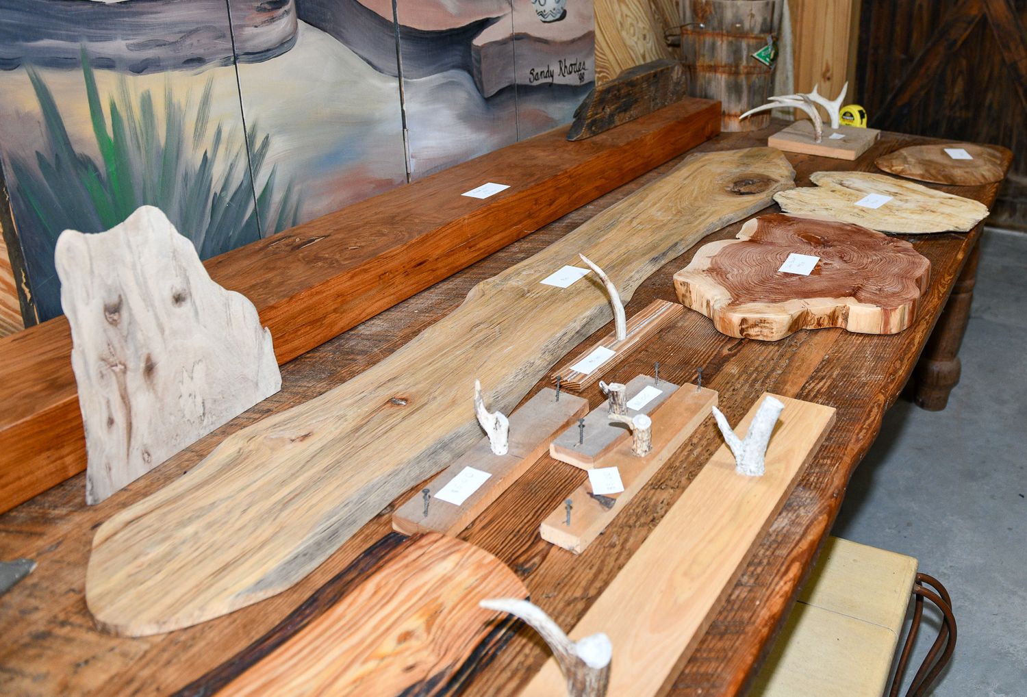 Various natural wood slabs arranged on a display table with artistic shapes and patterns.