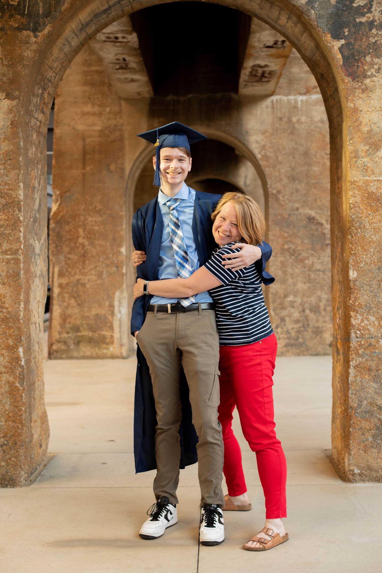 Graduation celebration captured in historic stone archway setting.