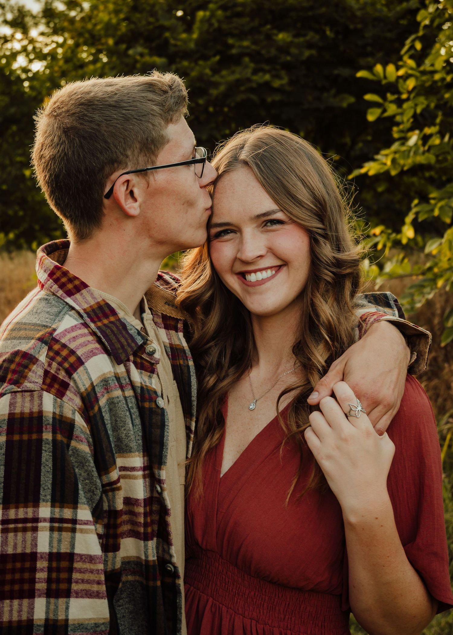 Guy kisses girl on forehead during couples photoshoot.