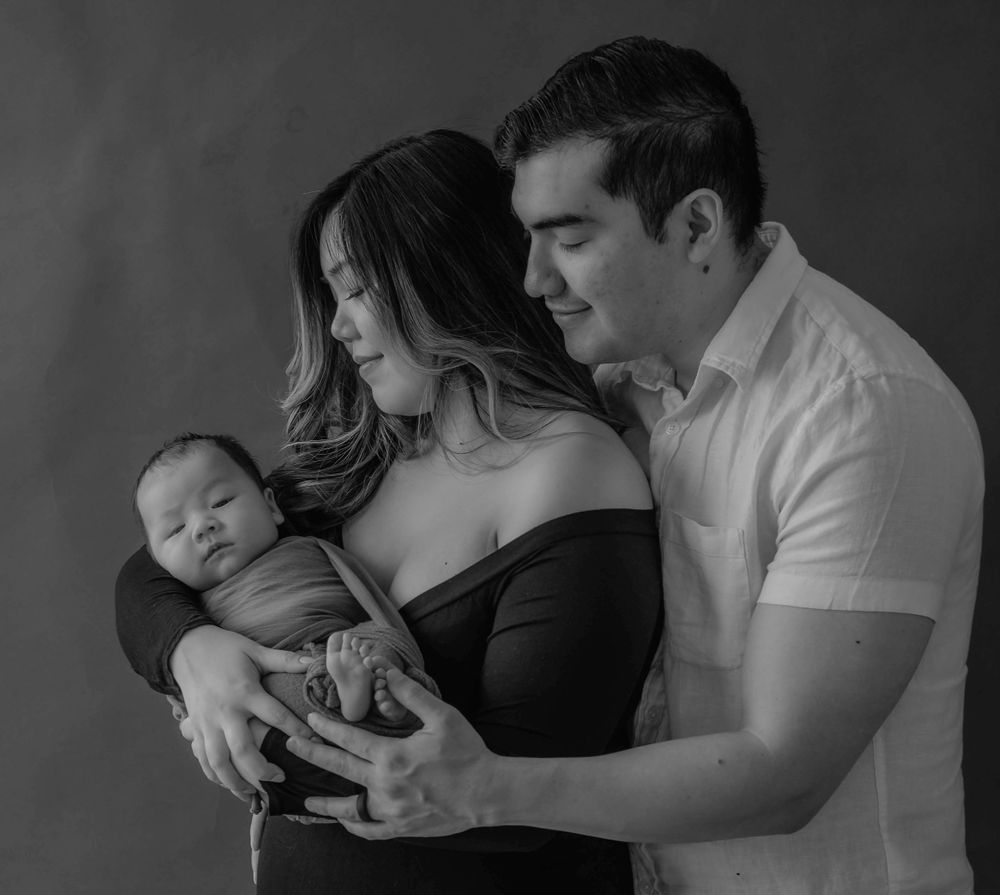 Couple look lovingly at newborn during photoshoot with Queens, Photographer, Sweet Sol Photo.