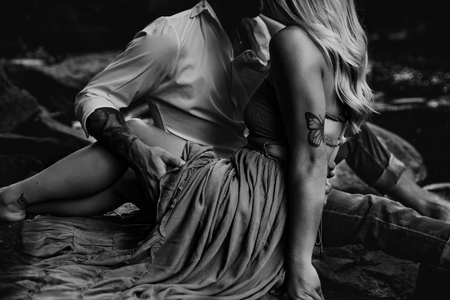 A black and white artistic boudoir photo series showing intimate poses in flowing fabric and soft lighting.