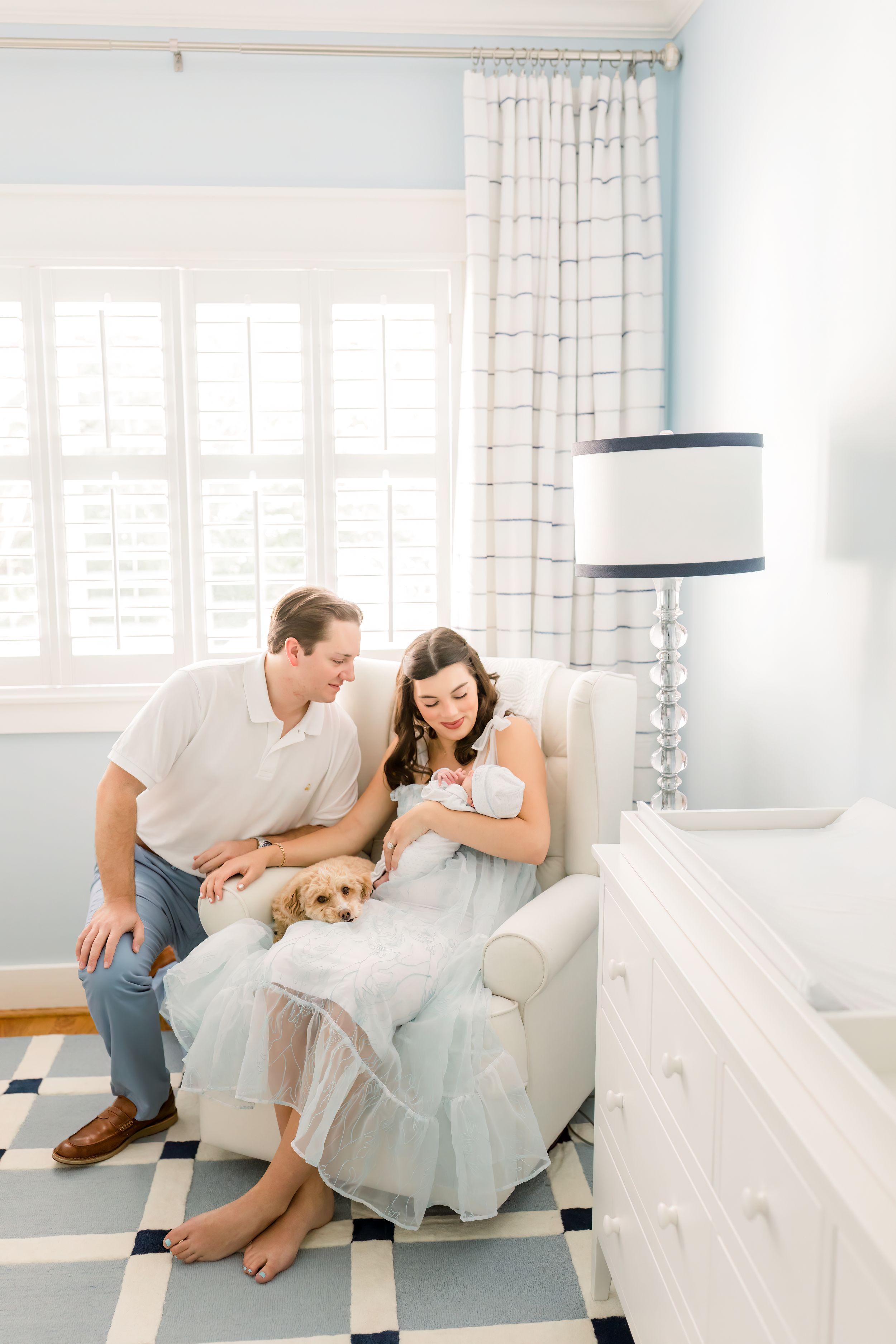 Peaceful nursery scene with checkered floor, armchair, and small dog by a bright window.