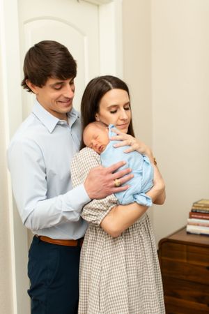 Parents sharing tender moment with newborn in home setting.