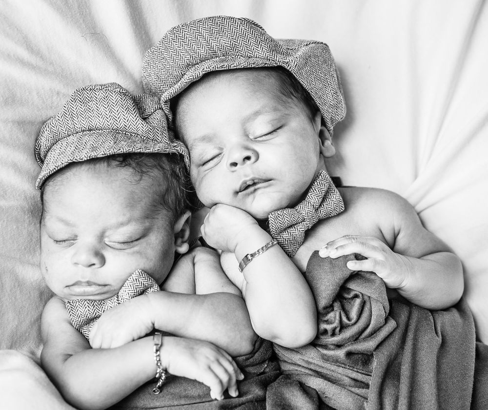 Five sequential black and white images of sleeping newborns wearing knit caps.