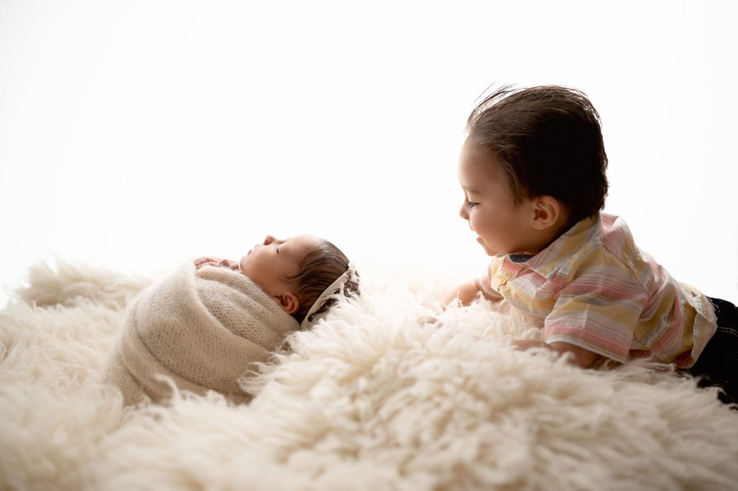 Newborn photography series showing peaceful sleeping baby on soft white textured fabric.