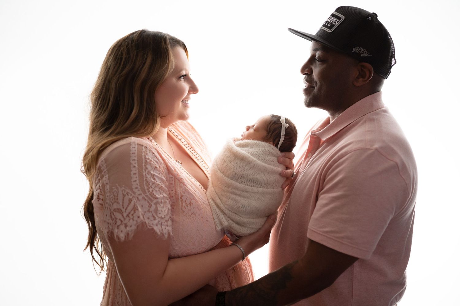 Family portrait series showing tender moments between parents and baby in soft lighting.
