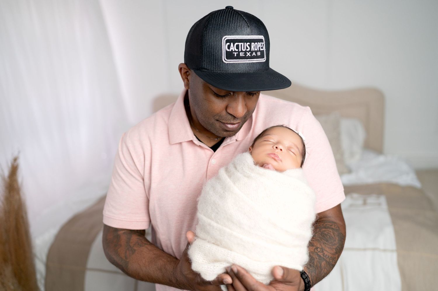 Studio portraits showing tender moments between parent and newborn in casual setting.