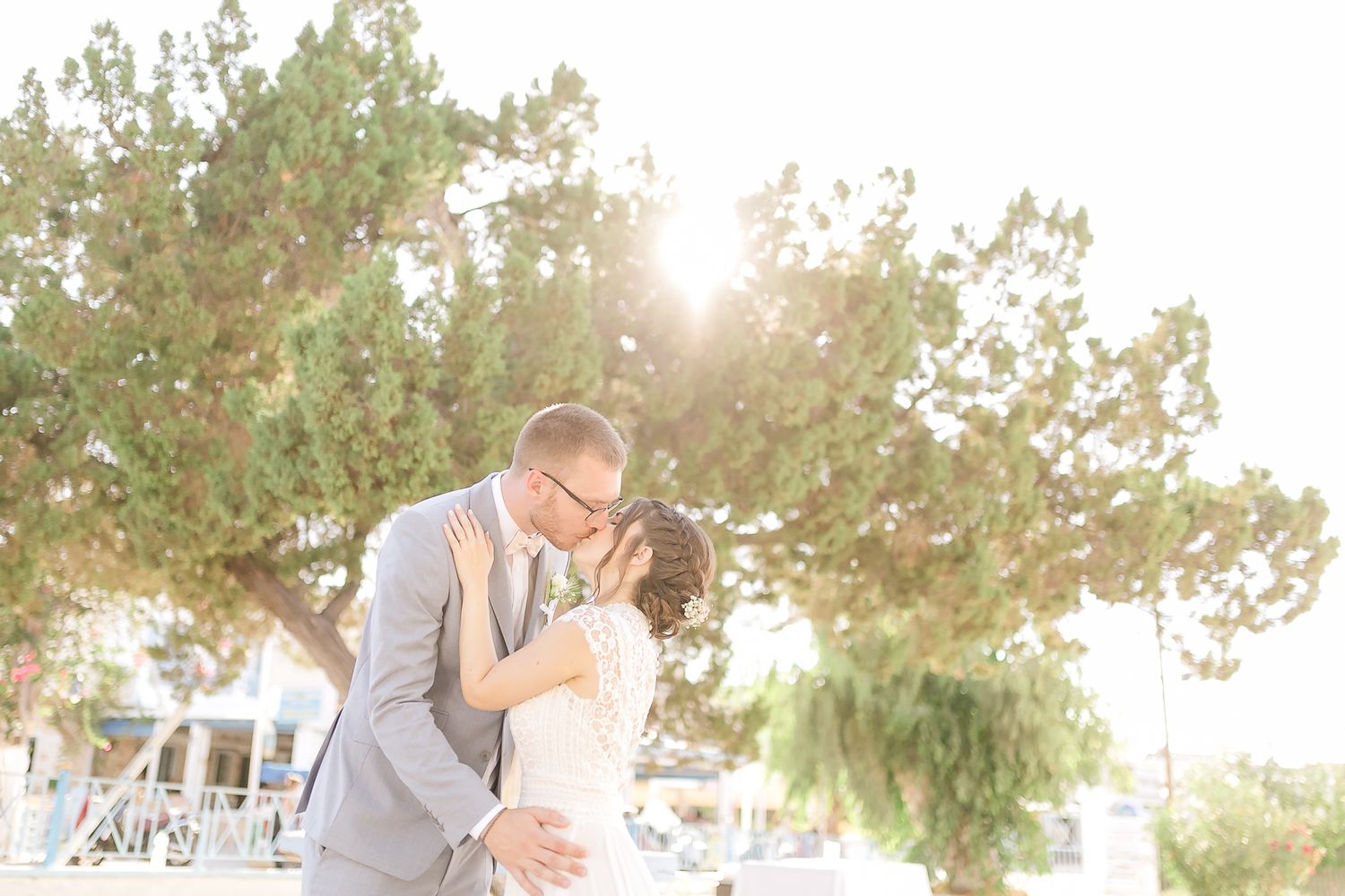 Wedding in Angistri island Greece. The newlyweds, with palm trees as their backdrop, share a special moment together.