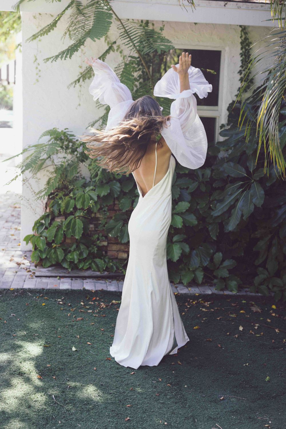 White flowy dress captured in motion against tropical garden background.