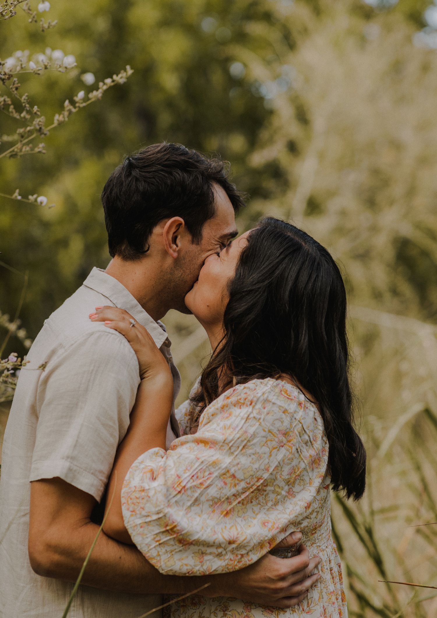 couple laughs candidly while each kissing each other on the cheek