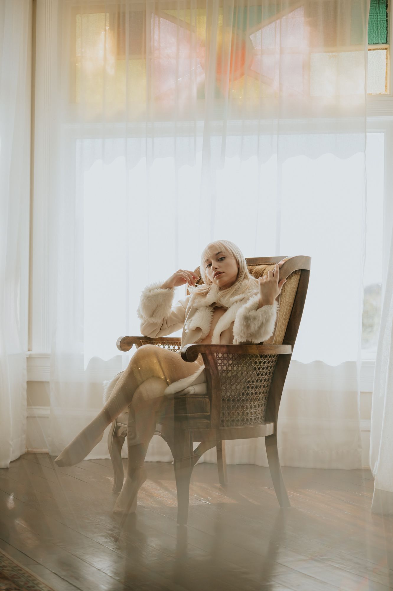 Portrait by La Mesa Photographer of woman in vintage chair and Victorian studio wearing fur coat