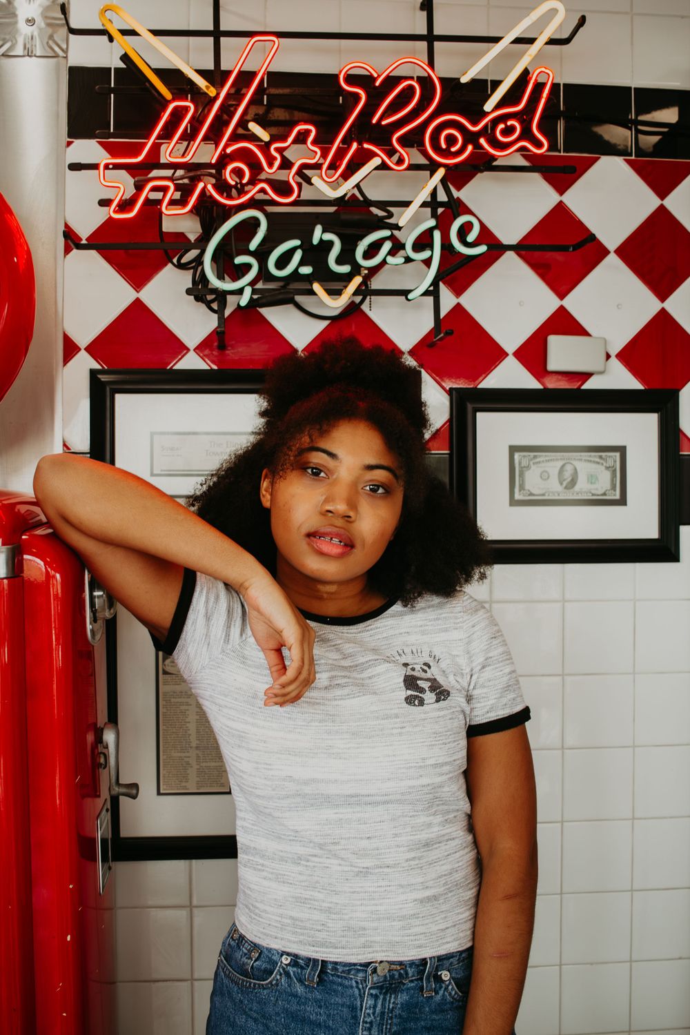 Retro diner interior with red and white checkered walls and neon signage.