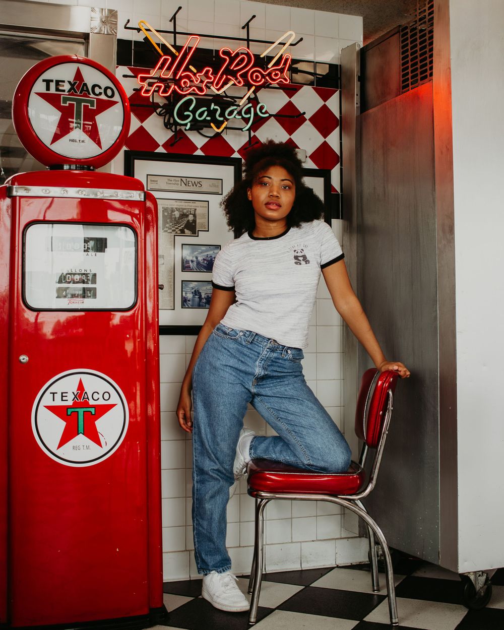 Vintage-style diner interior with red Texaco gas pump and checkered walls.