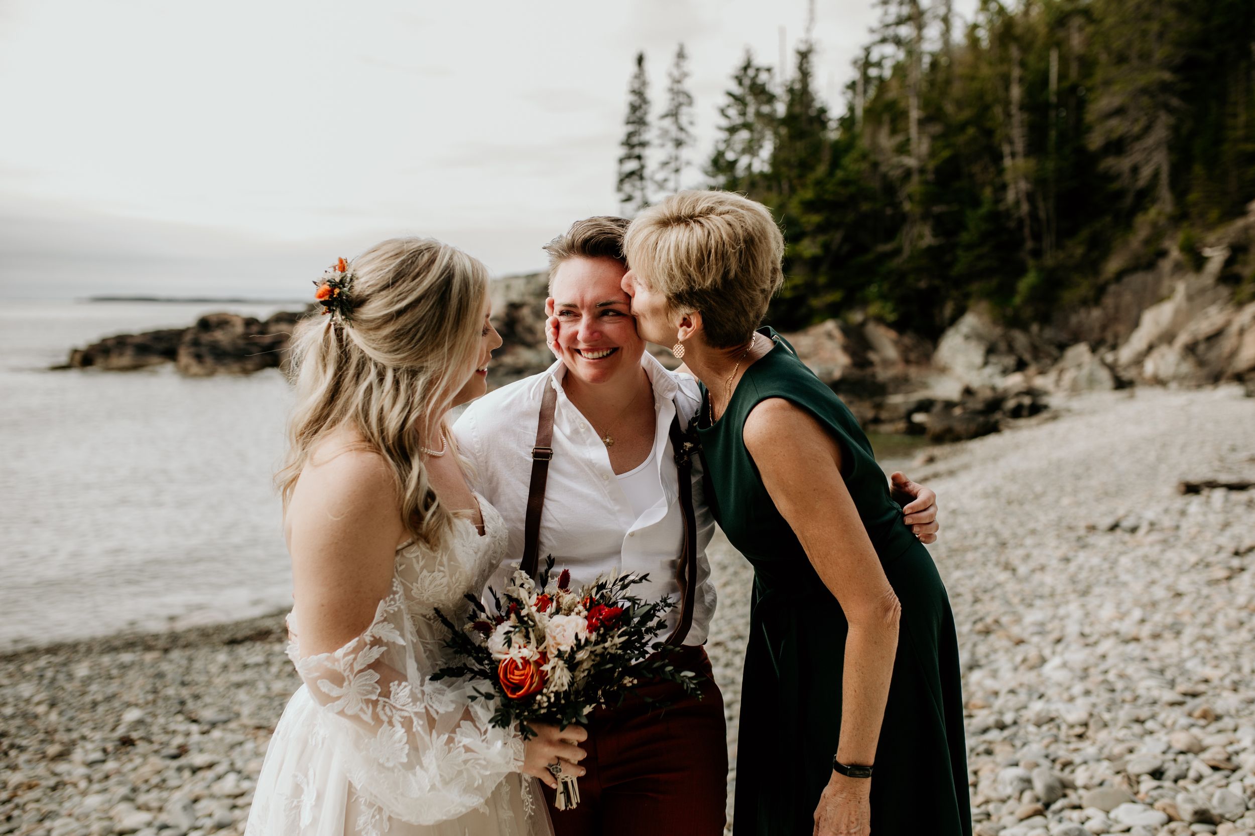 Intimate wedding moment captured on a scenic rocky coastline.