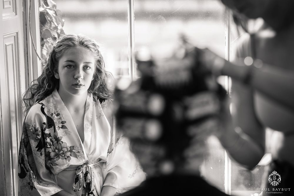 Candid black and white photo during hair styling session.