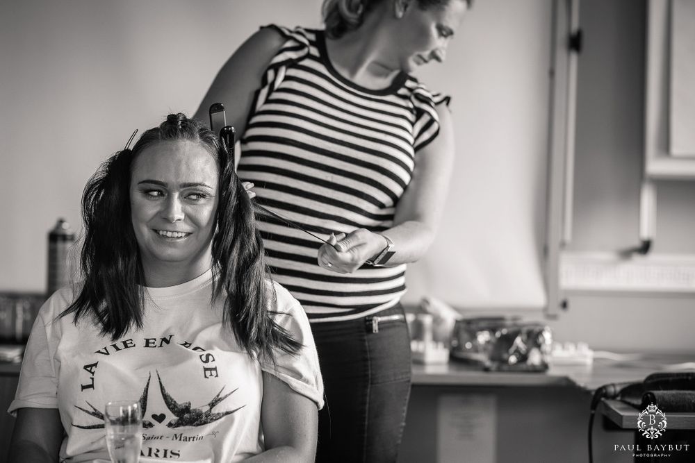 Mirror reflection shows styling in progress during wedding preparations.